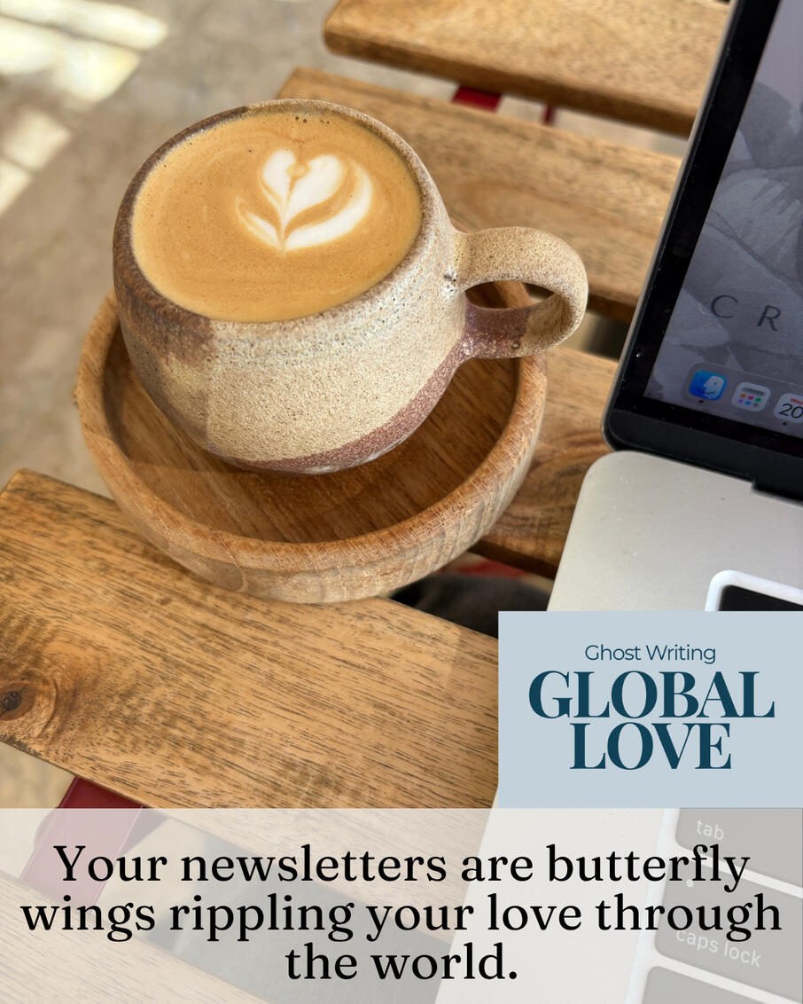 Latte with heart foam art in a ceramic cup beside an open laptop on a wooden table, with the words "Your newsletter is butterfly wings rippling your love through the world."