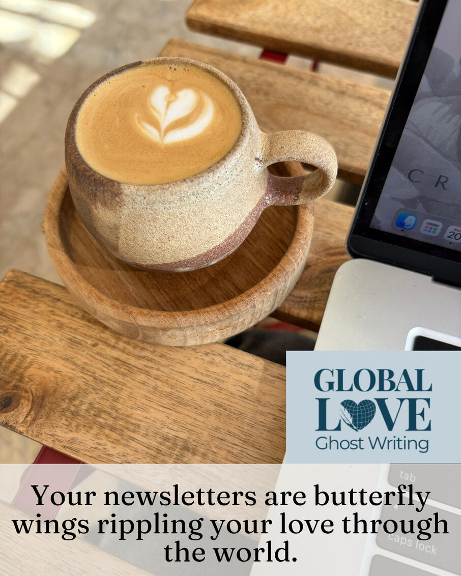 Latte with heart foam art in a ceramic cup beside an open laptop on a wooden table, with the words "Your newsletter is butterfly wings rippling your love through the world."